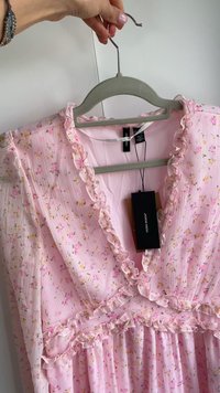 Rotes Blumenkleid mit Rüschendetails, leichtem Textilgewebe, langen Ärmeln, V-Ausschnitt und angehängten Markenetiketten.