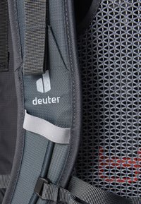 Gray fabric backpack feature with mesh panel, adjustable straps, and logo. Textured surface and contrasting accents enhance design.