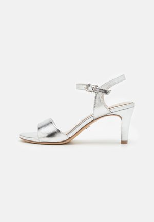 Silver metallic high-heeled sandal with an ankle strap, open toe, and a smooth finish. The heel is slender and approximately 3 inches tall.