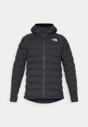 Schwarze Pufferjacke mit Kapuze, ausgestattet mit einem Reißverschluss auf der Vorderseite, einem gesteppten Muster und einem Logo auf der oberen linken Brust. Glatte Textur, leichter Design.