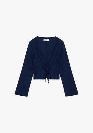 Blouse courte bleu marine à manches longues avec un col en V profond et deux attaches nouées à l'avant, en tissu texturé.
