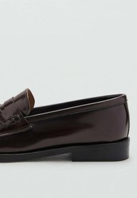 Braune Lederloafers mit glänzender Oberfläche, gefertigt mit einer gesteppten Oberseite, runder Zehenform und einer flachen, schwarzen Gummisohle.