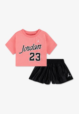 Rosa Crop-Top mit dem Schriftzug "Jordan 23" und schwarze Basketballshorts, beide mit weißem Jumpman-Logo.