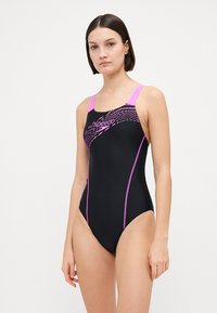 Μαύρο μαγιό με ροζ λουριά και επισημάνσεις στις ραφές. Διαθέτει δυναμικό σχέδιο κυμάτων στην περιοχή του θώρακα και εφαρμοστή σχεδίαση για καλύτερη απόδοση.