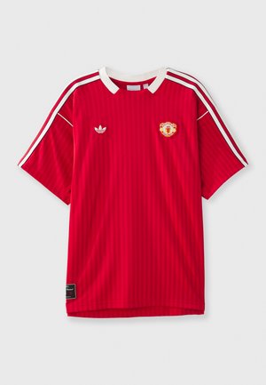 Red football jersey with vertical stripes, contrasting white collar, and three white stripes on sleeves. Features a badge and logo.