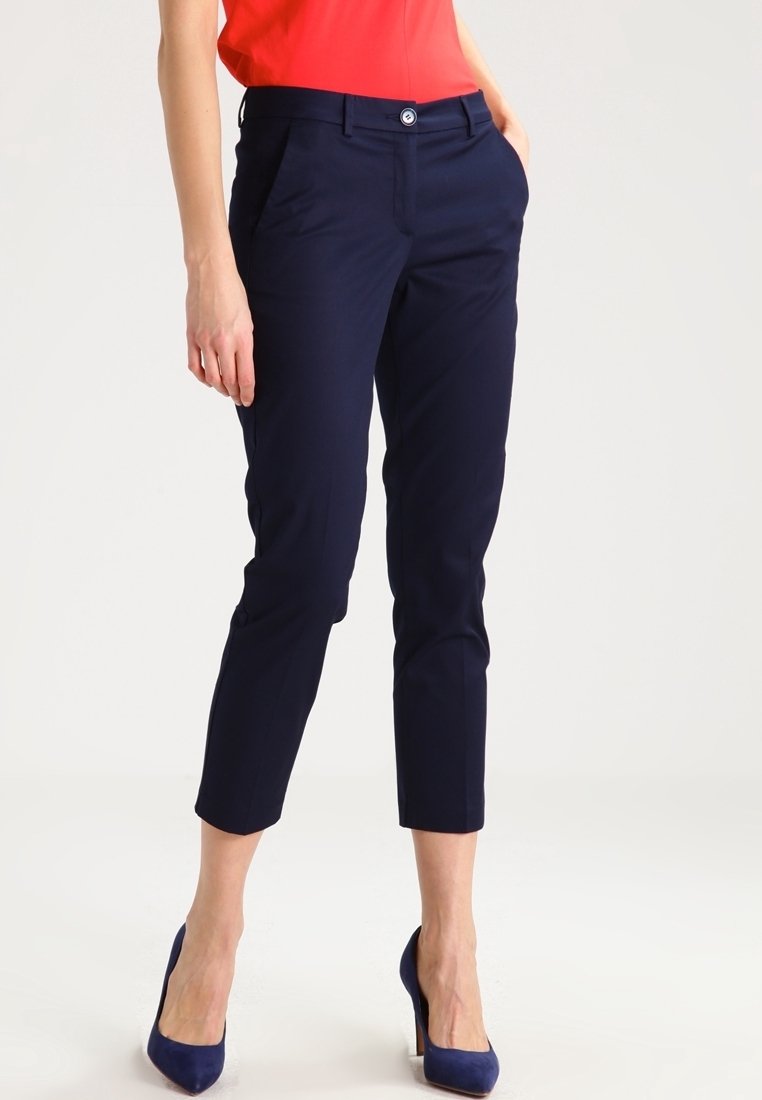 Marinblå skräddarsydda byxor med slim fit, med knäppning, två sidfickor och kort längd, tillverkade av ett slätt tyg.