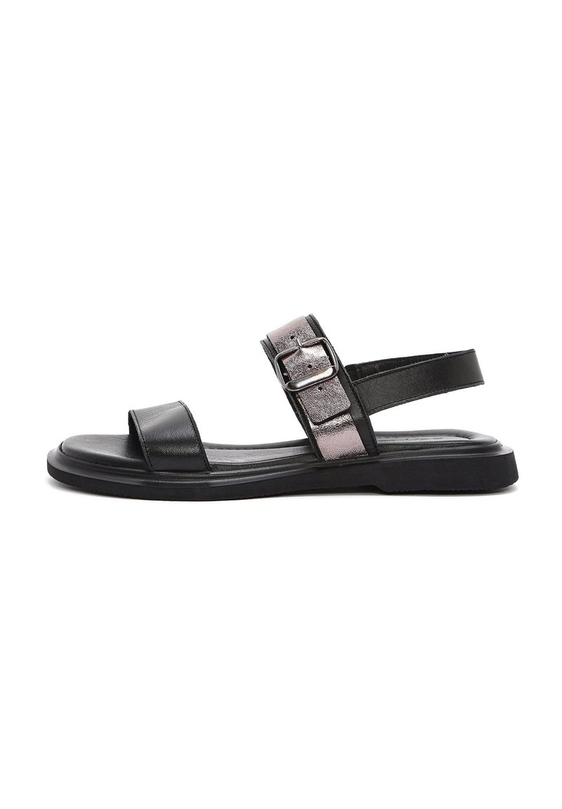 Sandalo in pelle nera con una ampia fascia anteriore, fibbia metallica regolabile e suola piatta. Presenta una texture liscia e un design minimalista.