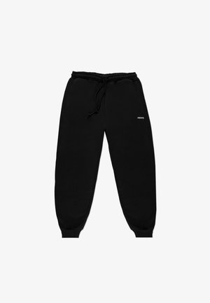 Czarne spodnie dresowe z miękkiej bawełny o zwężanych nogawkach, z elastycznym paskiem w talii i bocznymi kieszeniami. Na udzie znajduje się małe białe logo.
