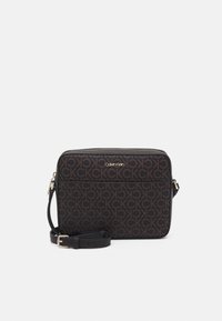 Torebka crossbody Calvin Klein, ciemnobrązowa z wzorem logo, zamek błyskawiczny, regulowany pasek, gładka faktura, akcenty w kolorze złotym.