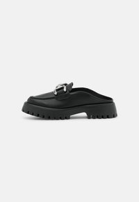 Sorte læder slip-on sko med en chunky sål og en sølv spænde accent. Har en glat overflade og et struktureret såldesign.