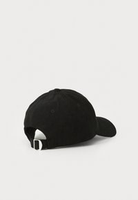 Svart kordfløyels baseballcaps med buet brem, seks ventilasjonsøyne, og justerbar stropp med metallspenne bak.