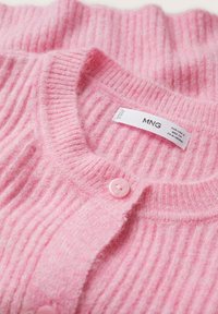 Różowy prążkowany kardigan wykonany z miękkiego materiału, z okrągłym dekoltem, zapięciem na guziki oraz metką z informacjami o marce.