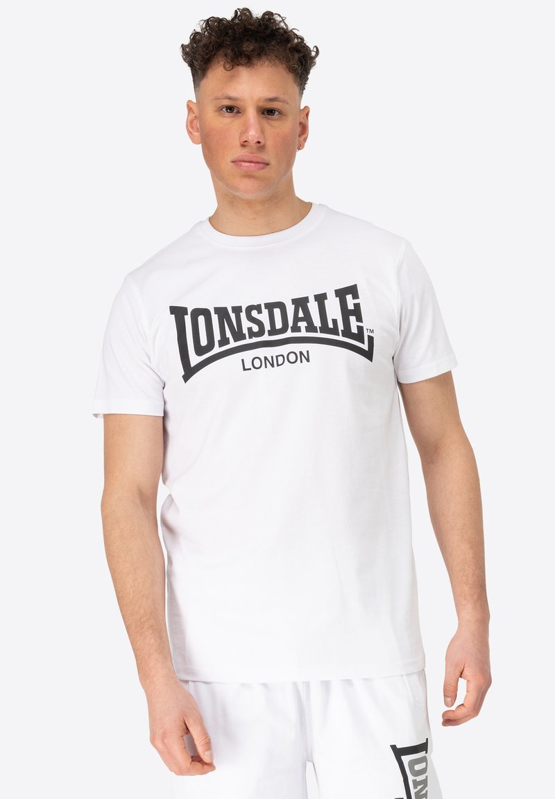 Bílý bavlněný tričko s černě potisknutým logem "LONSDALE" a "LONDON" v tučném písmu. Krátké rukávy a kulatý výstřih.
