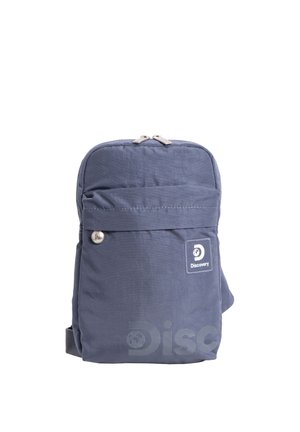 Blauer Rucksack der Marke Discovery mit Fronttasche, Reißverschluss und Logoaufnäher vor weißem Hintergrund.