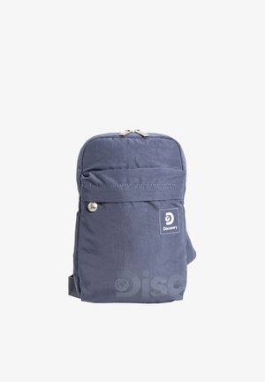 Blauer Rucksack der Marke Discovery mit Fronttasche, Reißverschluss und Logoaufnäher vor weißem Hintergrund.