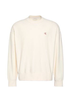 Kremowa bluza z długim rękawem z prążkowanymi mankietami i dołem, z małym czerwonym logo "cK" na lewej piersi.