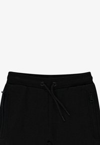 Zwarte joggerbroeken met een geribbelde elastische tailleband, een trekkoordsluiting en ritssluitingen aan de zijkanten. Gemaakt van een zachte katoenmix.