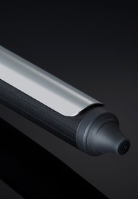 Marqueur noir avec une pointe arrondie, une prise texturée et une pince métallique sur une surface lisse. Présente un design élégant et minimaliste.