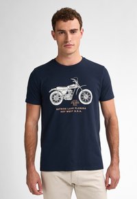 Námořnická modrá bavlněná tričko s grafikou motocyklu a textem: "Bayside Lane Florida Key West U.S.A." Jednoduchý design s kulatým výstřihem.