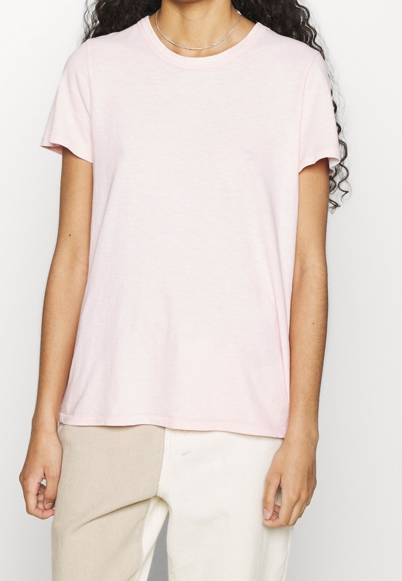 Light pink cotton t-shirt with short sleeves, a round neckline, and a relaxed fit. Smooth texture, no visible patterns or embellishments.