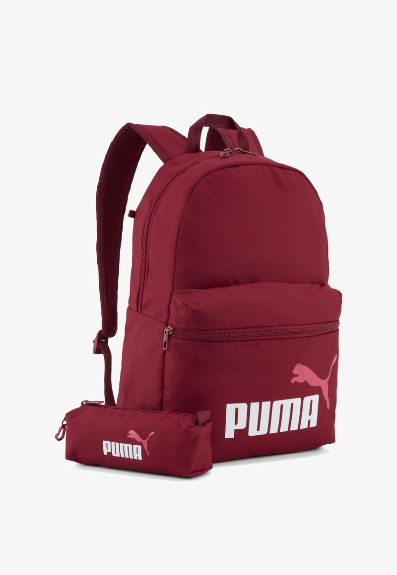 Sac à dos Puma rouge et trousse assortie avec logo Puma blanc, poche avant zippée et bretelles ajustables, présentés sur un fond uni.