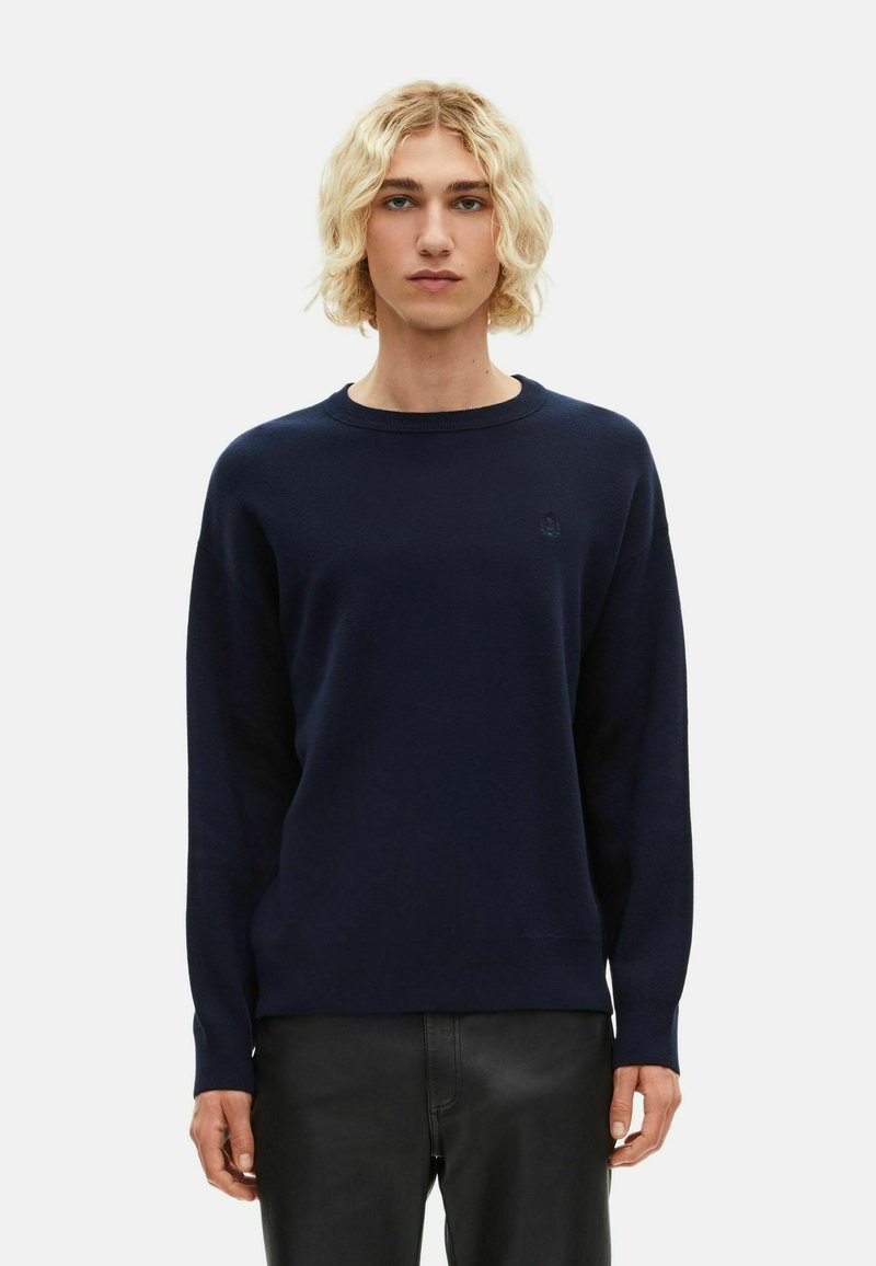 Marineblauwe sweater met een ronde halslijn en lange mouwen, gemaakt van een zacht materiaal met een subtiele logodetail op de borst.