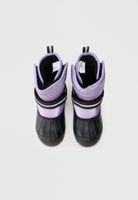 Bottes d'hiver avec une semelle en caoutchouc noir et une tige rembourrée violette, présentant une accent rayé et des sangles noires ajustables au niveau de la cheville.