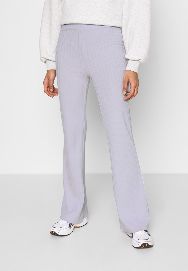 Ljusgrå ribbade flared byxor med hög midja. Slät textur med subtila vertikala ränder. Matchade med vita och svarta sneakers.