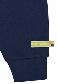 Navyblauwe katoenen sweatshirtmouw met een gestructureerd breipatroon, voorzien van een geweven label in groen en beige, genaaid in de manchette.