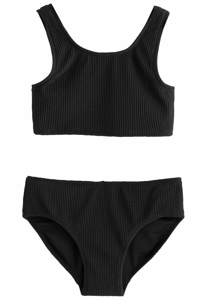 Set bikini nero a costine con top a bralette a scollo rotondo e parte inferiore a vita alta, realizzati in un tessuto testurizzato con dettagli delle cuciture.