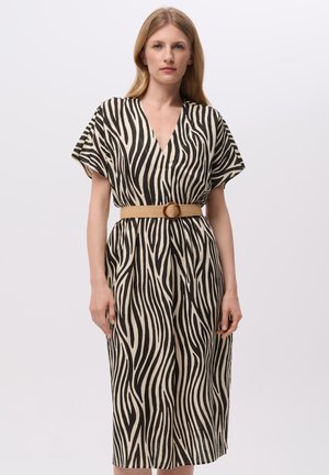 Robe à motif zèbre en tissu léger, avec un décolleté en V profond et des manches courtes. Une ceinture beige avec une boucle ronde marque la taille.