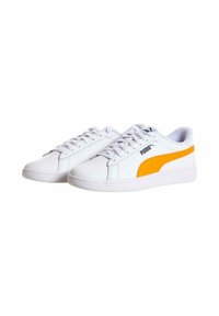 Sneakers bianchi in pelle con un design classico. Presentano una prominente striscia laterale gialla e lacci bianchi. Suola in gomma a profilo basso.