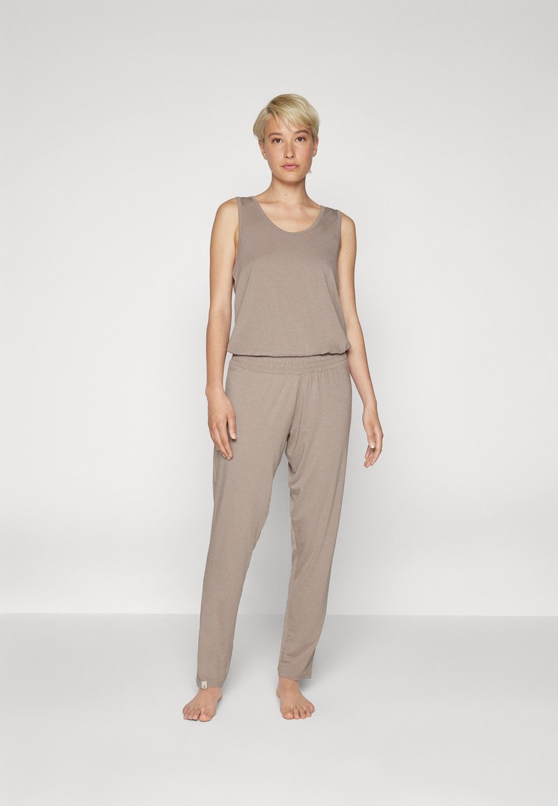 Pieskový loungewear set s bezrukávovým topom a elastickými nohavicami. Mäkká tkanina, voľný strih a minimalistický dizajn bez vzorov.