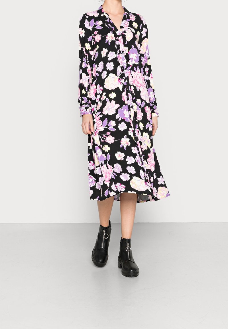 Schwarzes Kleid mit langen Ärmeln, das ein Blumenmuster in pinken und lila Farbtönen aufweist. Knielang mit einer geknöpften Vorderseite und einer lässigen Passform.
