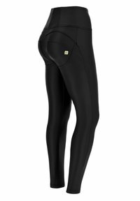 Leggings neri realizzati in materiale elastico con una texture liscia. Presentano un'alta vita e cuciture di tasca ben visibili sul retro.