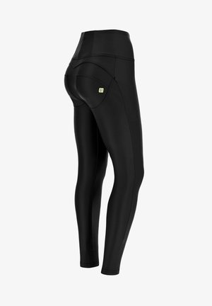 Mustat legginssit, jotka on tehty joustavasta materiaalista, jossa on sileä pinta. Varustettu korkealla vyötäröllä ja erottuvilla taskupistoilla takana.