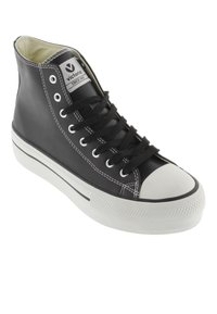 Zapatillas negras de caña alta hechas de cuero, con puntera de goma blanca, costuras blancas y cordones negros. Etiqueta de logo visible en el lateral.