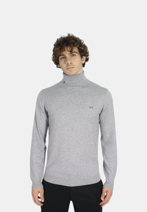 Maglione a collo alto grigio con maniche lunghe, realizzato in tessuto morbido, caratterizzato da un piccolo logo scuro sul petto e un design aderente.