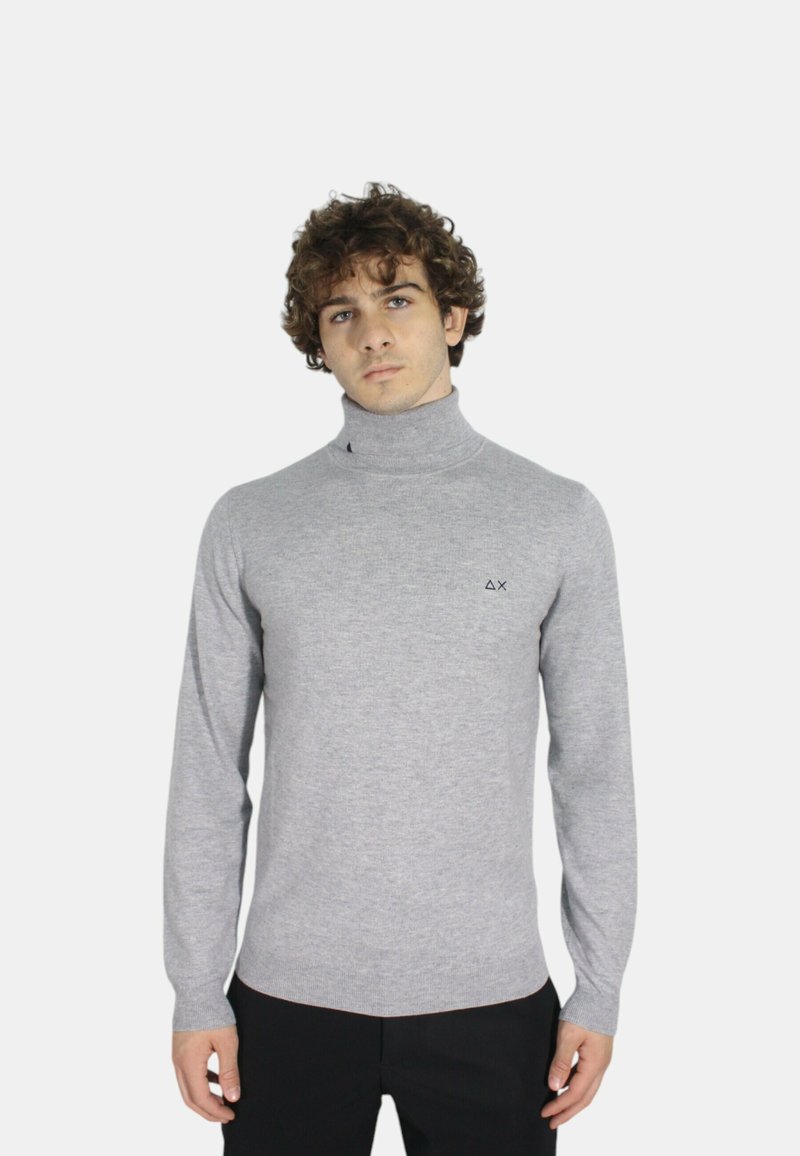 Maglione a collo alto grigio con maniche lunghe, realizzato in tessuto morbido, caratterizzato da un piccolo logo scuro sul petto e un design aderente.