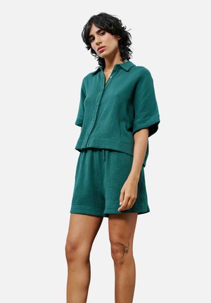 Ensemble en coton mélangé teal comprenant une chemise et un short, texturé avec une coupe ample. Comprend des manches courtes, un col, une fermeture à boutons et une taille élastique.