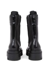 Černé kotníkové boty z kůže s žebrovanými detaily, zadním zapínáním na zip a silnými gumovými podrážkami s jemnou texturou a značkou na boku.