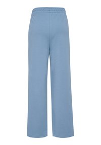 Hellblaue, weit geschnittene Hosen aus weichem Stoff, mit einem elastischen Bund und einer glatten Textur. Keine sichtbaren Taschen oder Muster.
