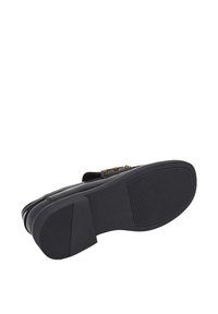 Zwarte sandalen met een platte, zwarte textured zool, voorzien van gouden versieringen op de band, met een eenvoudig en klassiek ontwerp.