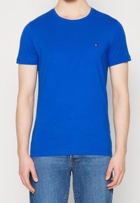 Blå crew-neck t-shirt i bomull, med korta ärmar och en liten logotypaccent på bröstet. Mjuk textur, regular fit.