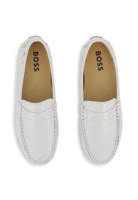 Λευκά δερμάτινα μοκασίνια με ραφές και ανάγλυφο λογότυπο στο πάνω μέρος. Μαλακός πάτος, στρογ γυλεμένη μύτη και λεία υφή.