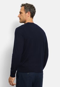 Marineblauwe trui met lange mouwen, ronde halslijn en geribbelde manchetten. Zachte textuur, eenvoudig ontwerp en naadloze schouders.