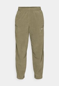 Olijfgroene fleece joggers met een elastische tailleband. Bevat een klein wit logo nabij de zak en een tapered leg ontwerp. Zachte textuur.