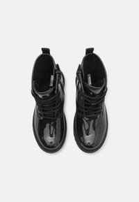 Bottines noires à talon avec une finition brillante et une texture pailletée, dotées de lacets et d'une fermeture éclair sur le côté. Marque Geox sur la semelle intérieure.