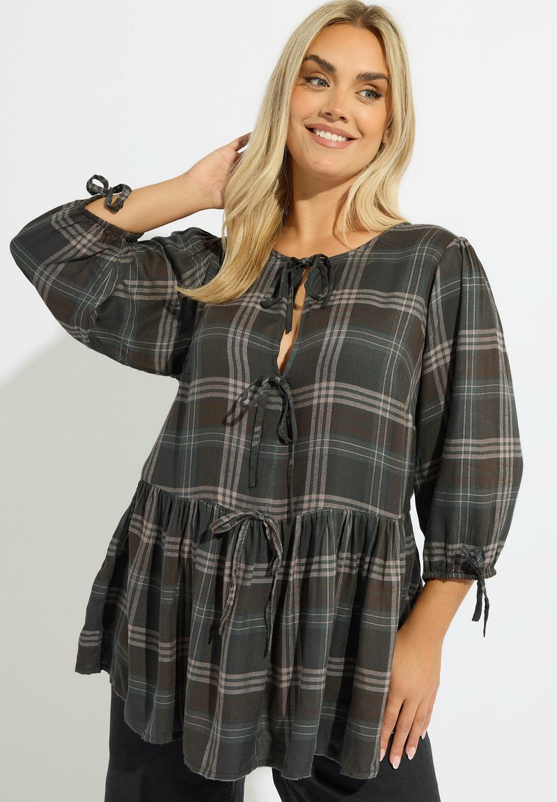 Blusa de cuadro negro y verde con mangas de globo de tres cuartos, escote con lazo y un dobladillo acampanado y fruncido, que presenta detalles con cordón.