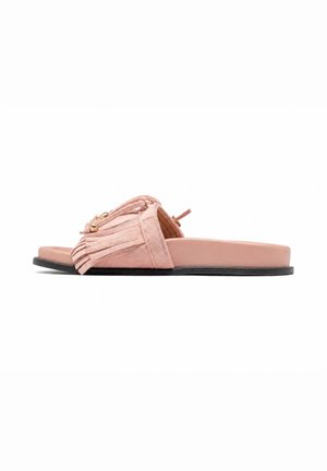 Sandalia plana de ante rosa con detalles de flecos y cuentas doradas en la tira ancha, suela negra y diseño de punta abierta.